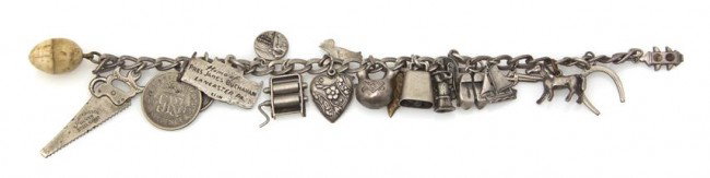 A Sterling Silver Charm Bracelet, 28.50 dwts.: A Sterling Silver Charm Bracelet, containing 20 vintage charms including an articulated pasta roller and an articulated water pump. Length 7 inches. 28.50 dwts.
