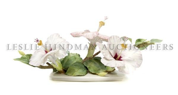 A Royal Worcester Dorothy Doughty Hibiscus Flower,: A Royal Worcester Dorothy Doughty Hibiscus Flower, having three blossoms on a leafy base. Width 12 1/4 inches.