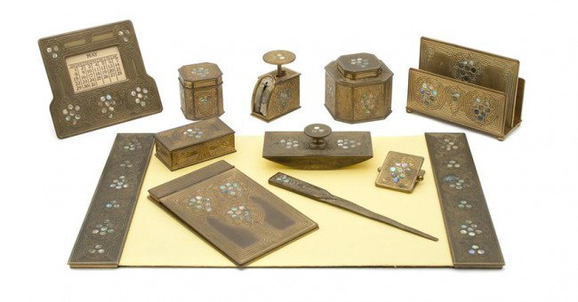 A Tiffany Studios Bronze Desk Set, Width of first: A Tiffany Studios Bronze Desk Set, in the Abalone pattern, comprising a letter rack (1156), a calendar (1166), an ink well (1157), a stamp box (1158), a paper clip (1165), a letter opener (1103), a po