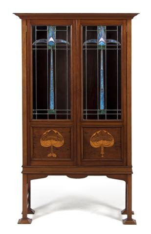 A Continental Art Nouveau Walnut Vitrine Cabinet,: A Continental Art Nouveau Walnut Vitrine Cabinet, having a rectangular top with molded cornice over a pair of leaded glass inset doors opening to a shelved interior, with stylized foliate satinwood in