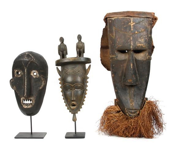 A Group of Three Masks, Congo, Borneo, and Ivory: A Group of Three Masks, Congo, Borneo, and Ivory Coast, the first having a stylized elongated human face with attached cloth at back, with raffia beard, the second, from Ivory Coast, depicted with two