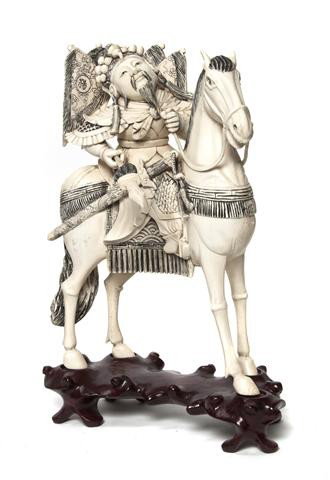 A Chinese Ivory Figure of a Horse and Rider, Height: A Chinese Ivory Figure of a Horse and Rider, the man depicted with armor and holding a spear, raised atop a fitted wood base. Height of carving 8 3/4 inches. Property from the Estate of Tom G. and Mar