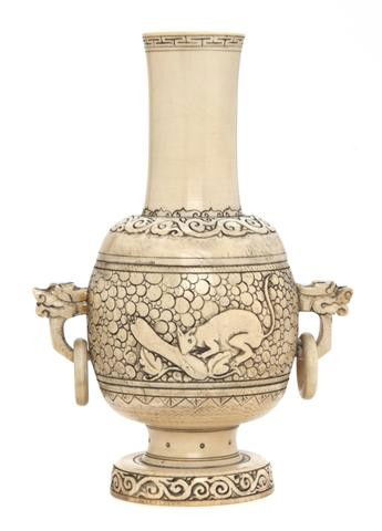 A Chinese Carved Ivory Bottle Vase, Height 6 1/4 i: A Chinese Carved Ivory Bottle Vase, having flared and waisted neck above bulbous body with carved decoration of a rabbit with a carrot, flanked by dragon form handles. Height 6 1/4 inches.
