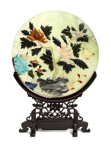 A Chinese Hardstone Table Screen, Diameter of plaq: A Chinese Hardstone Table Screen, of circular form, the semi-translucent green stone disk having applied hardstone decoration of flowering plants on rocks made up of carved rose quartz, marble, lapis 