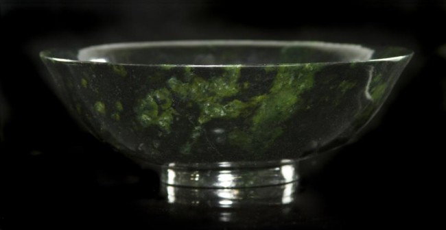 A Chinese Mossy Spinach Jade Bowl, Diameter 5 3/4 : A Chinese Mossy Spinach Jade Bowl, of deep green colored stone with various inclusions raised on a circular foot ring. Diameter 5 3/4 inches. Property from the Collection of Mr. and Mrs. John F. Monro