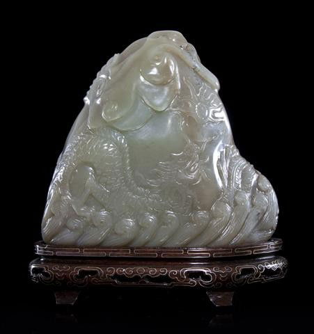 A Jade Boulder, Height 5 3/8 inches.: A Jade Boulder, of celadon and brown colored stone, depicting a dragon above the waves, raised on a silver wire inlaid wood base. Height 5 3/8 inches. Property of a Private Collector, Chicago, Illinoi