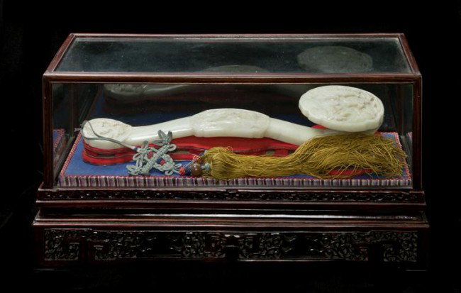 A White Jade Ruyi Scepter, Length 16 5/8 inches.: A White Jade Ruyi Scepter, of opaque white stone, having carved decoration throughout and hung with silk tassels, contained in a fitted wood and glass case. Length 16 5/8 inches. Property of a Private