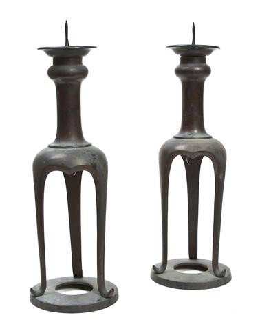 A Pair of Japanese Bronze Altar Candlesticks, Heig: A Pair of Japanese Bronze Altar Candlesticks, late Meiji period, each of columnar form raised on three shaped supports joined by a ring base. Height 14 1/4 inches. Property from the William H. Moore T
