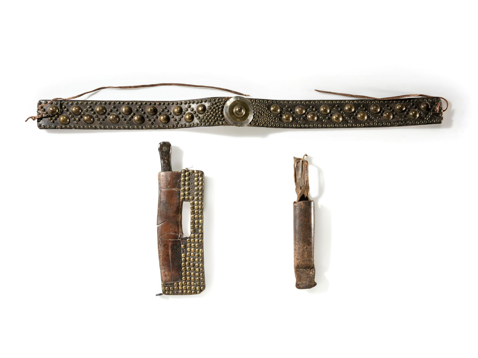 Blackfeet Tacked Belt, with Knife Sheath and Whetstone Case: Blackfeet Tacked Belt, with Knife Sheath and Whetstone Case fourth quarter 19th century made from harness leather; rectangular knife sheath is decorated with brass tacks and incised decorations; compl