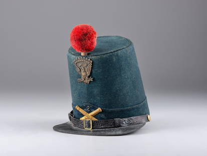 [MILITIA]. Model 1851 artillery shako. Manufactured by F.H. Lambert.&#160;: [MILITIA]. Model 1851 artillery shako. Manufactured by F.H. Lambert.&#160; Visor to crown 6 3/4 in. Model 1851 blue wool shako with tarred leather visor and strap with 2 brass buttons (minor wear, som