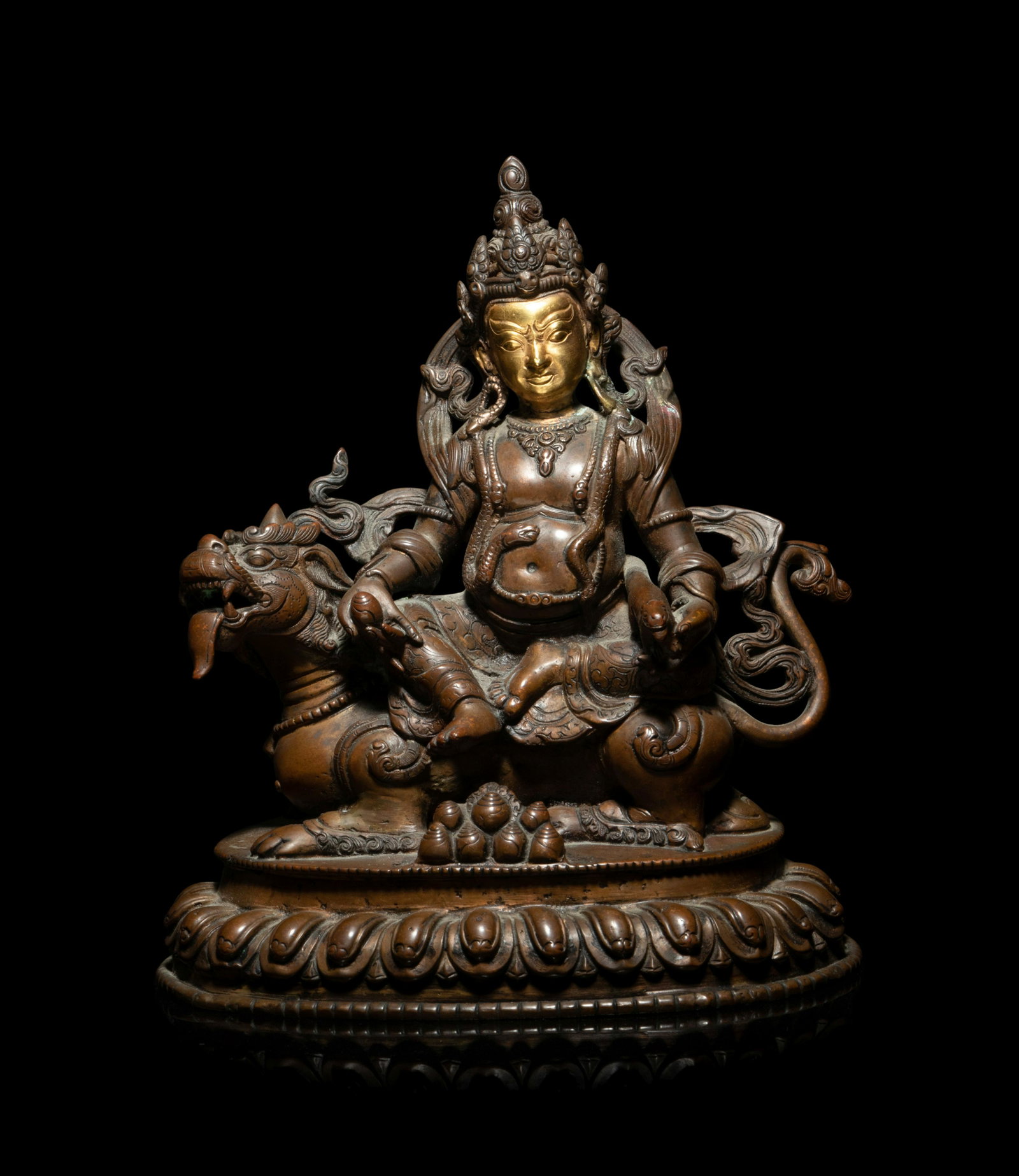 A Sino-Tibetan Gilt Bronze Figure of a Bodhisattva Vaishranava: A Sino-Tibetan Gilt Bronze Figure of a Bodhisattva Vaishranava depicted seated across the back of a tiger, all supported by lotus base. Height 7 1/2 in., 19.05 cm.