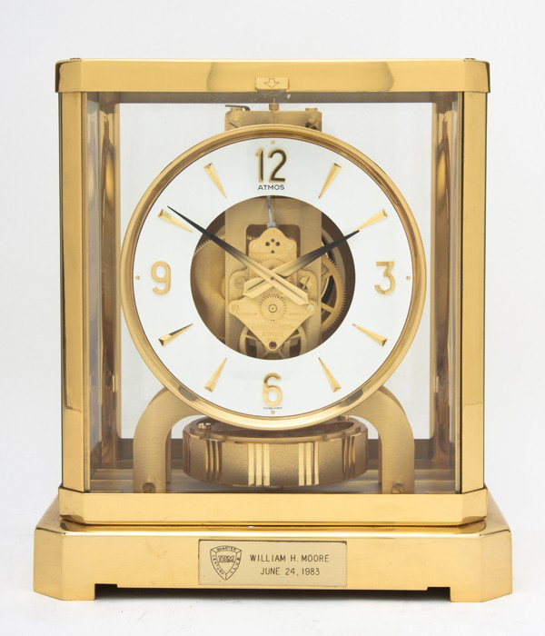 A Swiss Brass and Glass Atmos Clock, Jaeger-LeCoul: A Swiss Brass and Glass Atmos Clock, Jaeger-LeCoultre, of typical rectangular form, with Arabic numerals. Height 9 1/4 inches. Property from the William H. Moore Trust, Dorset, Vermont