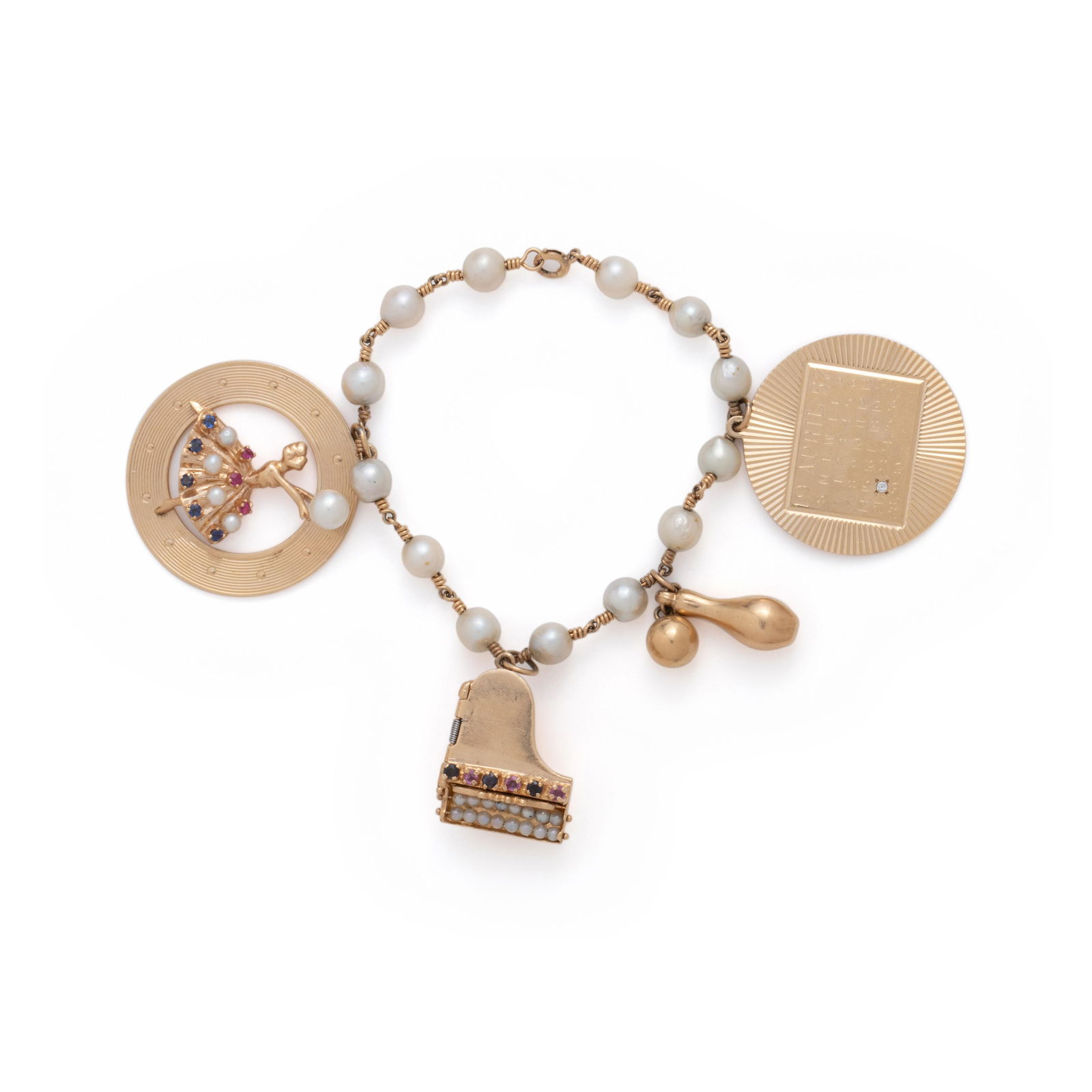 YELLOW GOLD AND CULTURED PEARL CHARM BRACELET: YELLOW GOLD AND CULTURED PEARL CHARM BRACELET Consisting of a pearl and wire link bracelet suspending a LIFE BEGINS calendar charm for April 22, 1957, a bowling pin and ball charm, a hinged piano char
