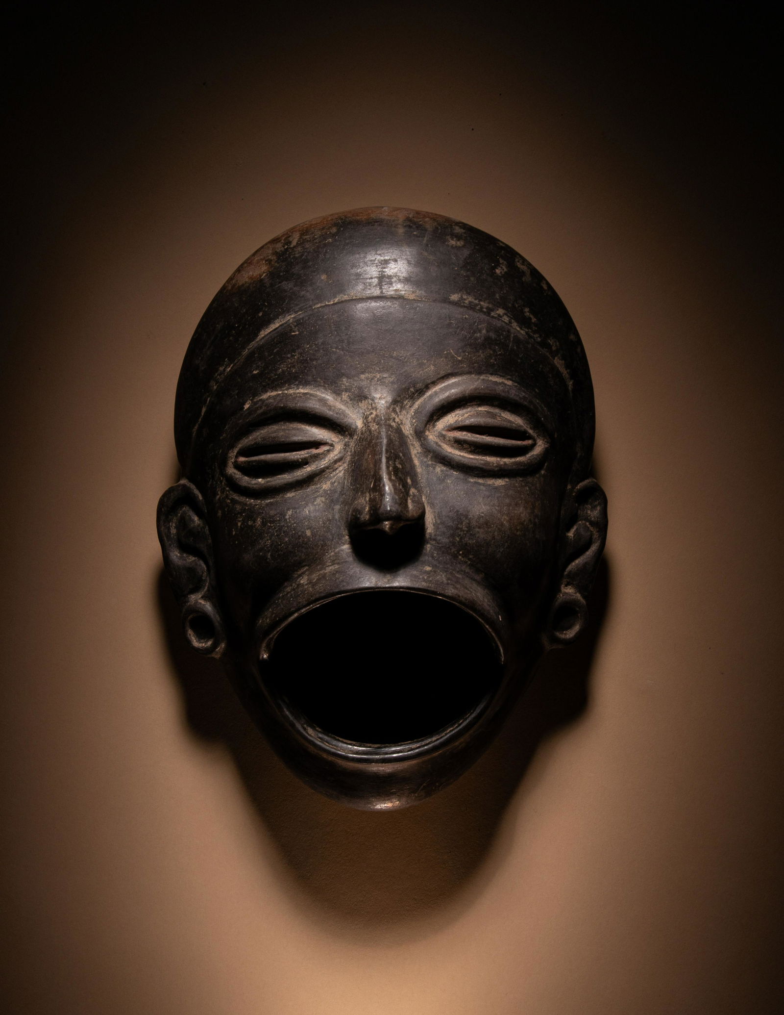 An Olmec Blackware Effigy Vessel in the Form of a Human Face Length 9 1/2 inches (24.13 cm). (1 of 3)