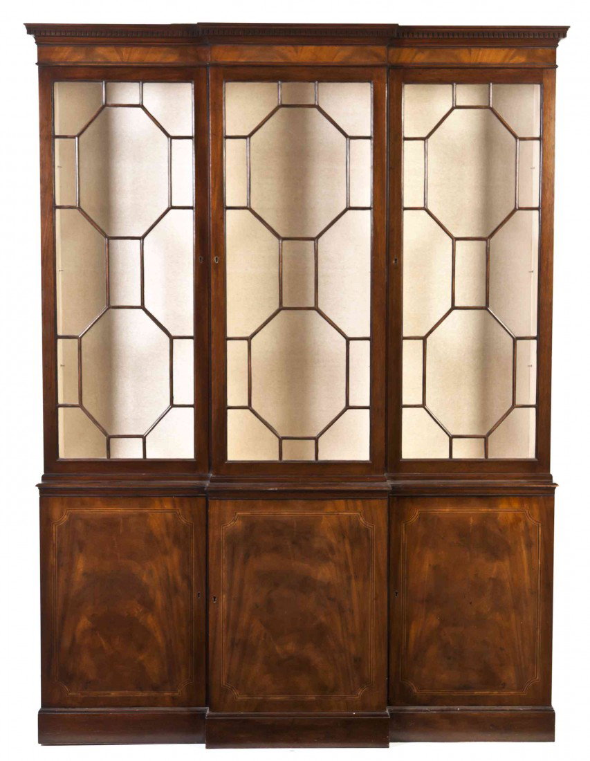 A Georgian Style Mahogany Breakfront Bookcase, Bake: A Georgian Style Mahogany Breakfront Bookcase, Baker, having a dentiled cornice over three glazed doors and three panel doors, raised on a plinth base. Height 79 1/4 x width 58 1/2 x depth 14 1/4 inch