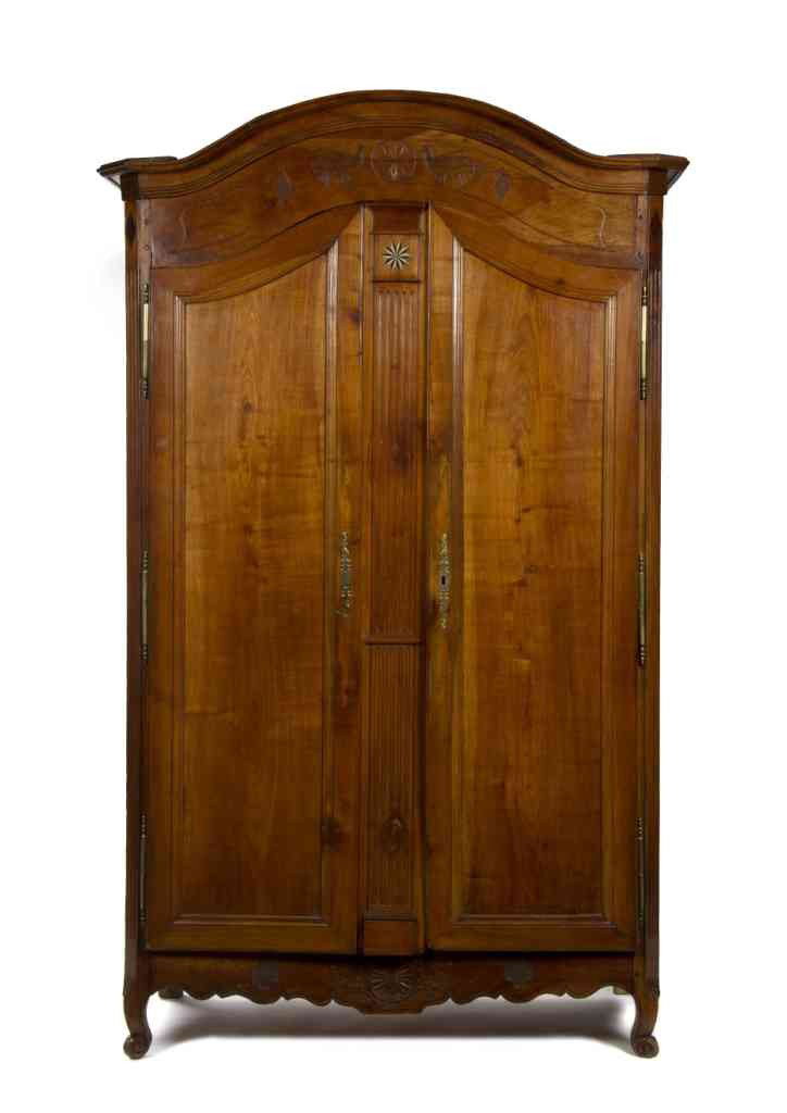 A French Cherry Armoire, Height 92 x width 53 x de: A French Cherry Armoire, having an arched molded cornice over the conforming frieze with carved bird and pinwheel decoration above two paneled doors over a shaped carved skirt raised on scrolled feet.