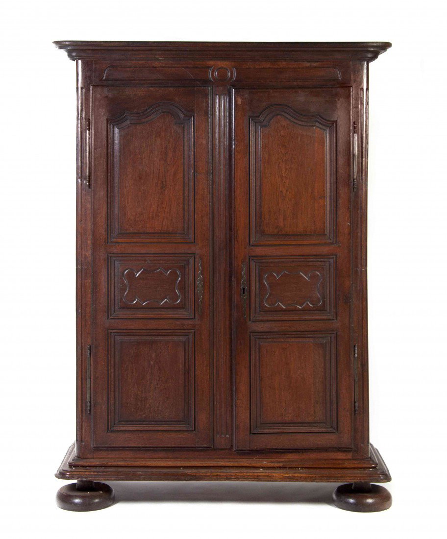 A French Provincial Oak Armoire, Height 84 x width: A French Provincial Oak Armoire, having a molded cornice over two paneled doors raised on flattened ball feet. Height 84 x width 60 x depth 25 inches.