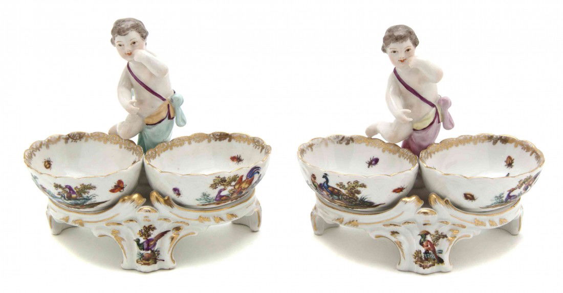 A Pair of Berlin (K.P.M.) Figural Double Salts, Wi: A Pair of Berlin (K.P.M.) Figural Double Salts, each surmounted with a putto over the double bird decorated bowls, having scepter mark to base. Width 5 1/2 inches.