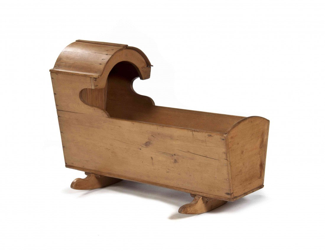 An English Pine Cradle, Length 35 1/2 inches.: An English Pine Cradle, having an arched section over the tapering rectangular case raised on two rockers. Length 35 1/2 inches.