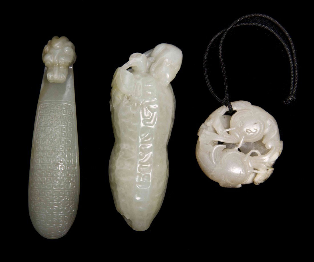 A Group of Three Carved Jade Articles, Length of l: A Group of Three Carved Jade Articles, comprising a garment hook, a pendant, and a figure of a peanut with a mouse. Length of longest 4 1/8 inches.