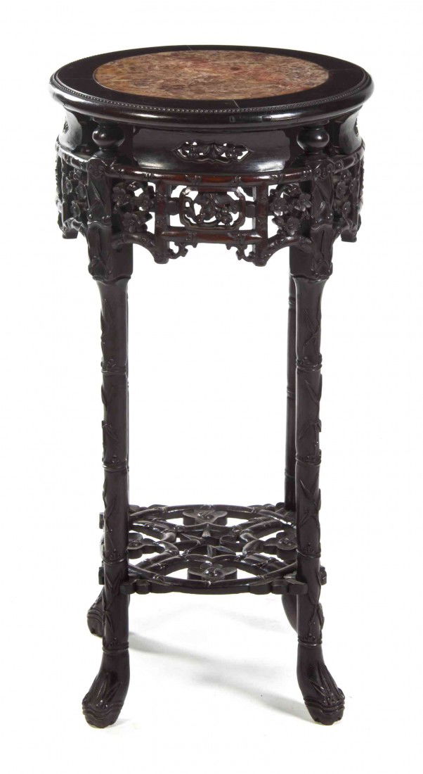 A Chinese Carved Hardwood and Marble Inset Pedesta: A Chinese Carved Hardwood and Marble Inset Pedestal Table, the circular top over the pierce carved conforming frieze raised on vine decorated legs joined by a pierce carved medial shelf. Height 32 x d