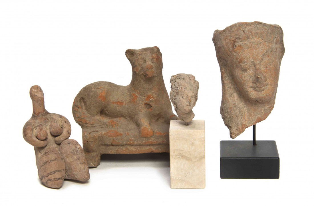 A Group of Four Pottery Antiquity Fragments, Heigh: A Group of Four Pottery Antiquity Fragments, comprising a mask fragment set on a wood stand, a classical bust set on a marble stand, a seated female figure and a figure of a recumbent dog. Height of t