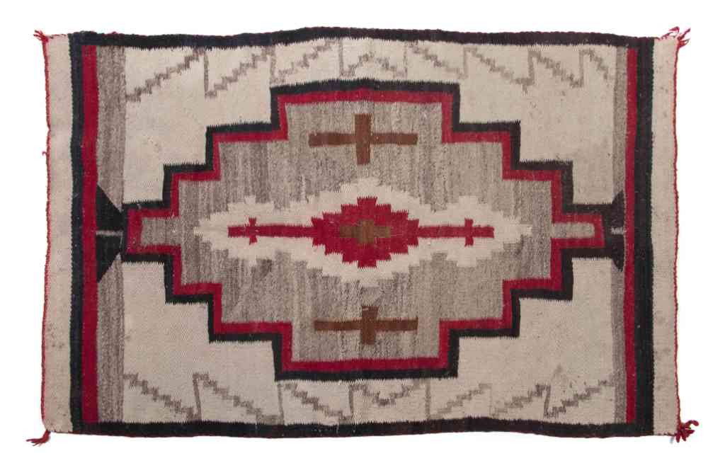 A Navajo Blanket, Height 51 x width 34 inches.: A Navajo Blanket, having a center medallion with red, black and grey decoration. Height 51 x width 34 inches. Property from the Estate of Norma Seidman, Lincolnwood, Illinois