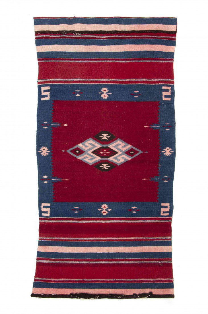 A Navajo Blanket, Height 54 x width 27 inches.: A Navajo Blanket, having a central diamond with red, white and blue decoration. Height 54 x width 27 inches. Property from the Estate of Norma Seidman, Lincolnwood, Illinois