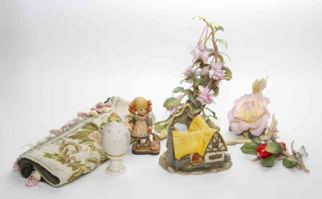 A Collection of Fifteen Decorative Table Articles: A Collection of Fifteen Decorative Table Articles, comprising four Cybis porcelain eggs, Goebel porcelain egg, four Anri carved wood figures, three porcelain foliate groups, a model of a house, a doll