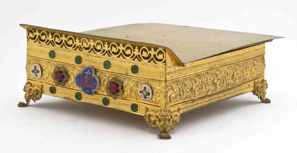 An Enameled Brass Bible Stand, Width 11 1/2 inche: An Enameled Brass Bible Stand, the square top with incised cross, the molded frieze with scrolling foliate, jeweled and enameled decoration. Width 11 1/2 inches.