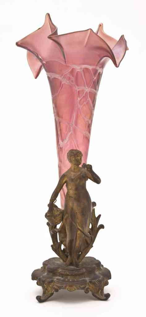 An Iridescent Glass and Gilt Metal Figural Epergn: An Iridescent Glass and Gilt Metal Figural Epergne, depicting a woman with a basket of flowers raised on a stepped base with scrolling toes, the glass of tapering form with ruffled rim. Height 14 1/2 