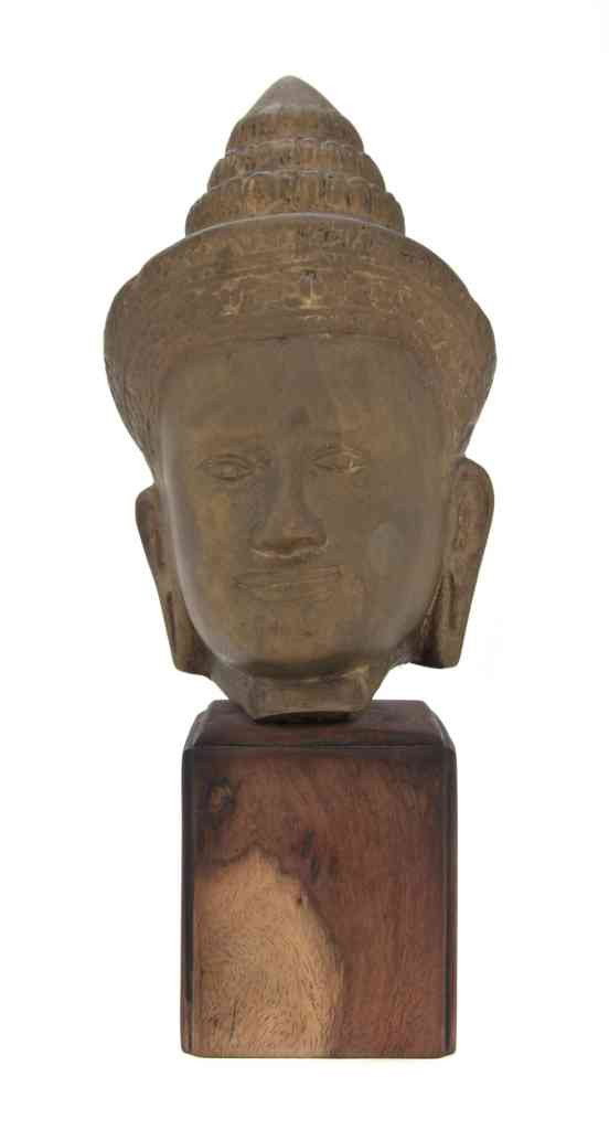 A Khmer Style Gilt Bronze Model of a Head, Height: A Khmer Style Gilt Bronze Model of a Head, the figure depicted in a headdress with elongated earlobes, set on a wood base. Height overall 11 1/2 inches.