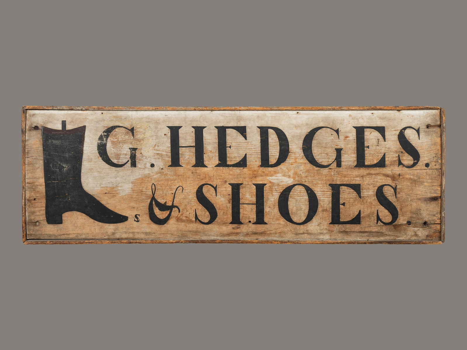 A Black Painted Pine Cobbler's Sign: A Black Painted Pine Cobbler's Sign Circa 1810 inscribed G. HEDGES SHOES. Height 16 3/4 x width 52 inches. Provenance: Ex Barry Cohen Collection David Schorsch, Woodbury, Connecticut.
