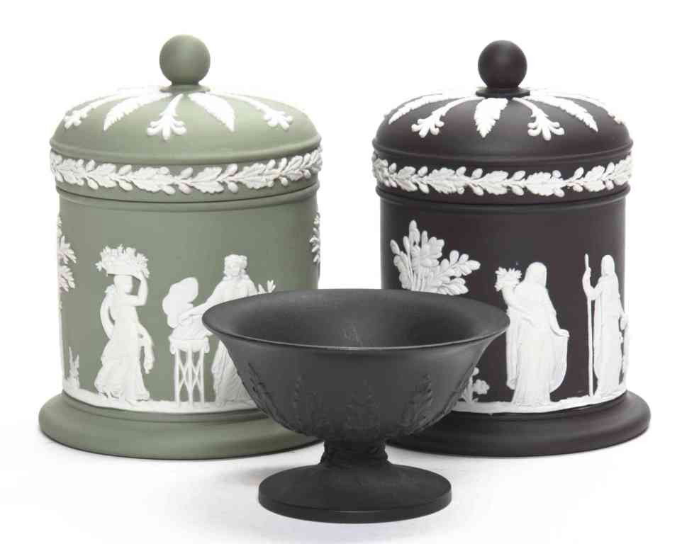 Two Wedgwood Jasperware Cigarette Jars, Height of: Two Wedgwood Jasperware Cigarette Jars, each with classical decoration, one in white on green, the other white on black, marked Wedgwood, Made in England, together with a basalt footed bowl, marked We