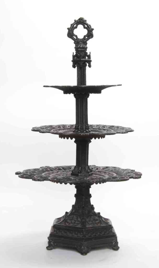A Cast Iron Three-Tier Gothic Style Epergne, Heigh: A Cast Iron Three-Tier Gothic Style Epergne, with quatrefoil and trefoil piercings throughout, raised on a hexagonal base terminating in six upturned feet. Height 20 1/4 x diameter 11 1/8 inches.