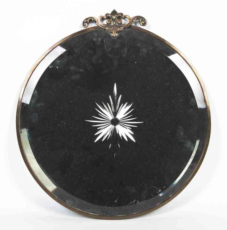 A Brass Mounted Mirror, Height 15 1/4 x width 14 1: A Brass Mounted Mirror, having a circular beveled plate centered with an etched starburst motif. Height 15 1/4 x width 14 1/8 inches.