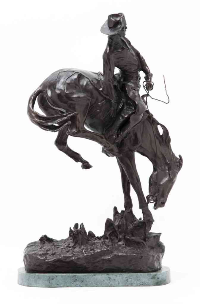An American Bronze Figural Group, after Frederic R: An American Bronze Figural Group, after Frederic Remington, The Outlaw, depicting a man on bucking horseback, set on a marble base. Height overall 22 3/4 inches.