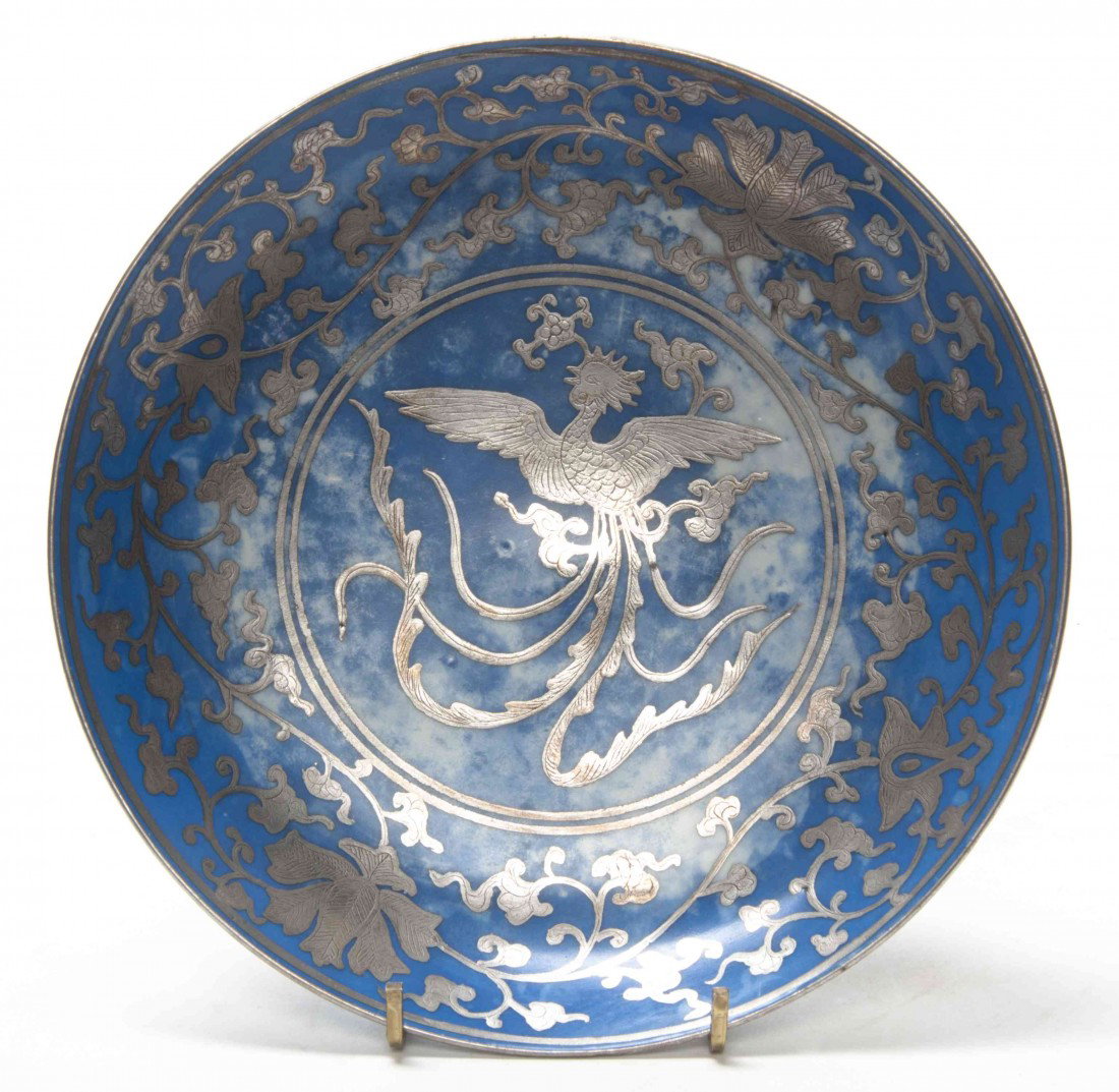 A Chinese Silver Overlay Dish, Diameter 8 1/2 inch: A Chinese Silver Overlay Dish, the central roundel depicting a phoenix surrounded by a border of scrolling lotus vines and blossoms, the underside with a four character underglazed blue reign mark wit