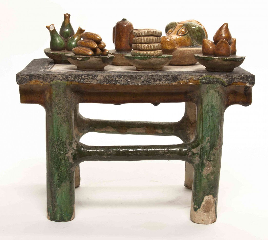 A Chinese Sancai Glazed Pottery Table with Food, W: A Chinese Sancai Glazed Pottery Table with Food, Tang Dynasty style, having a rectangular top over four supports joined by stretchers, with a collection of ceramic food displayed on the top including