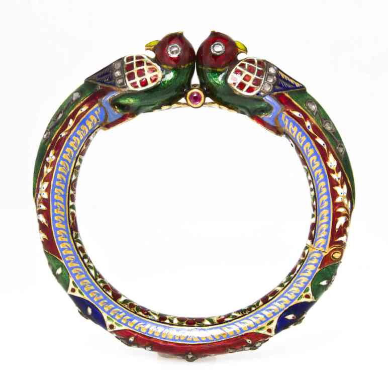 A Gold, Polychrome Enamel and Diamond Mughal Bracel: A Gold, Polychrome Enamel and Diamond Mughal Bracelet, Early 20th Century, in a peacock and foliate motif accented with red, green, blue and white enamel, containing numerous lasque cut diamonds. Prov