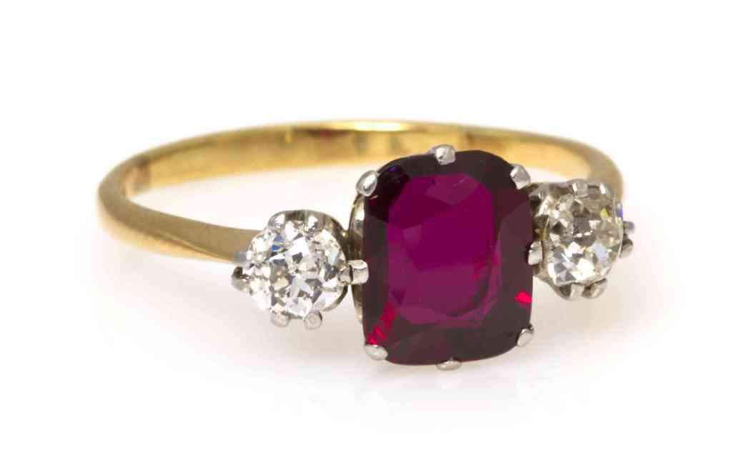 An Edwardian 18 Karat Yellow Gold, Platinum, Ruby a: An Edwardian 18 Karat Yellow Gold, Platinum, Ruby and Diamond Ring, containing one cushion shape brilliant cut ruby weighing approximately 1.10 carats and two old mine cut diamonds weighing approximat