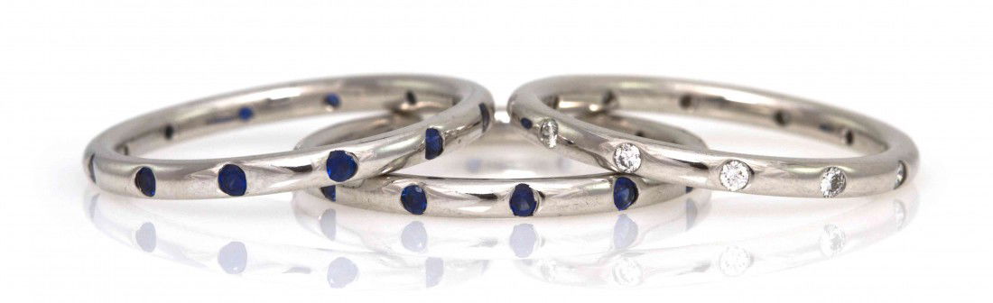 A Group of 18 Karat White Gold, Sapphire and Diamo: A Group of 18 Karat White Gold, Sapphire and Diamond Stacking Rings, consisting of one band containing numerous diamonds weighing approximately 0.12 carat total and two bands containing sapphires weig