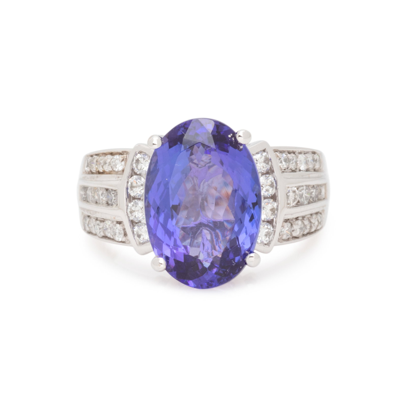 TANZANITE AND DIAMOND RING: TANZANITE AND DIAMOND RING Containing one oval mixed cut tanzanite measuring approximately 14.00 x 9.60 x 5.65 mm and 36 round brilliant cut diamonds weighing approximately 0.70 carat total. Mounted i