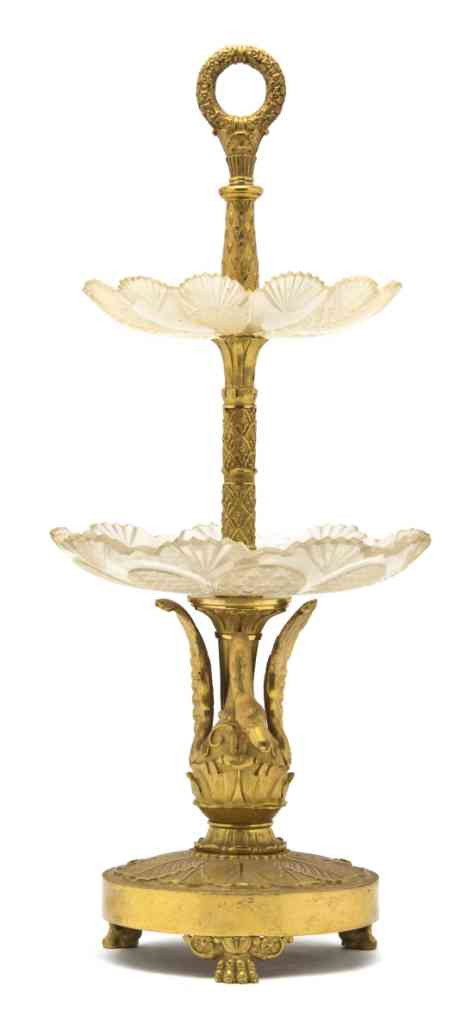 An Empire Style Gilt Bronze and Cut Glass Two-Tier: An Empire Style Gilt Bronze and Cut Glass Two-Tiered Tazza, having a ring handle over the two graduated circular tiers, raised on a swan form support. Height 17 1/2 inches.