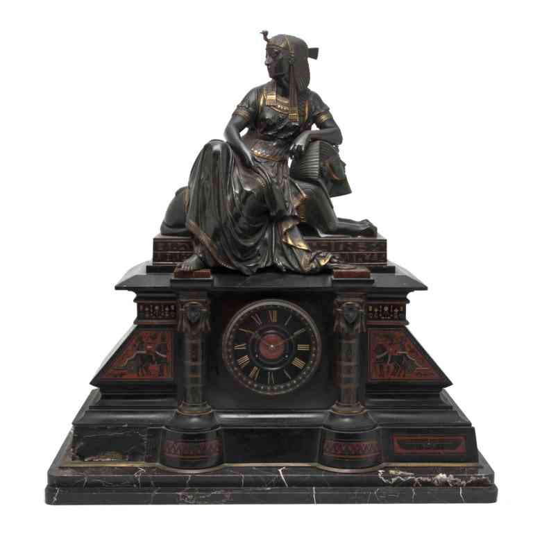 An Egyptian Revival Bronze and Slate Figural Mante: An Egyptian Revival Bronze and Slate Figural Mantel Clock, surmounted with a robed Egyptian female signed Leon Pilet and seated on a sphinx, the slate case having a circular dial with Roman numerals a