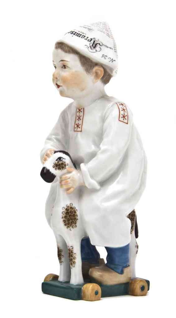 A Meissen Porcelain Figure, Hentschl, Height 6 3/4: A Meissen Porcelain Figure, Hentschl, depicting a boy in a newspaper hat riding a toy horse, having crossed swords mark in underglaze blue, impressed W120 incised 156. Height 6 3/4 inches. Property fr