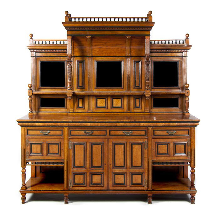 A Victorian Walnut and Ebonized Server, Height 93 : A Victorian Walnut and Ebonized Server, in two parts, the superstructure having a spindled gallery and a dentiled cornice over turned columns and a segmented mirrored backsplash, the base having a rec