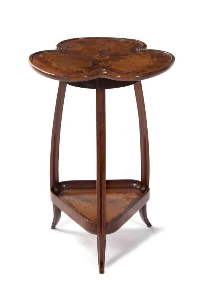 A French Marquetry Art Nouveau Table, Louis Major: A French Marquetry Art Nouveau Table, Louis Majorelle, the trefoil form top with foliate inlays, signed L. Majorelle in marquetry, raised on carved legs joined by triangular medial shelf. Height 30 in