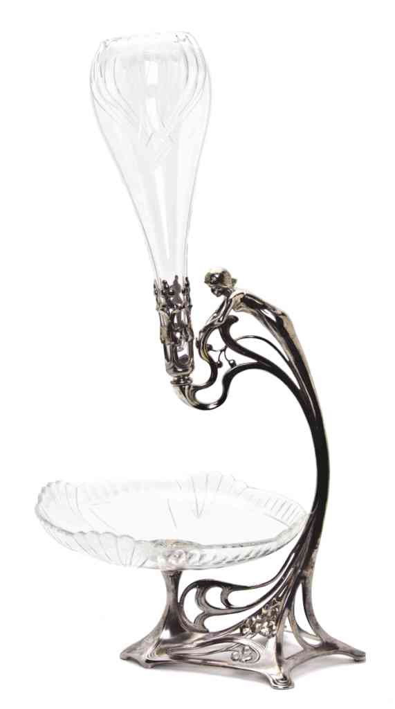 An Art Nouveau Silvered Metal Figural Epergne, He: An Art Nouveau Silvered Metal Figural Epergne, with a single support in the form of a stylized maiden and two etched glass bowls decorated with seed heads, raised on a pierced scrolling base. Height 2