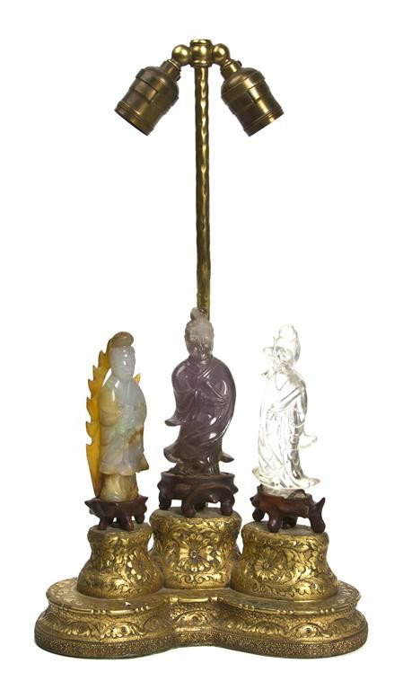 A Group of Three Hardstone and Jade Models of Guan: A Group of Three Hardstone and Jade Models of Guanyin, comprised of one rose quartz, quartz and jadeite models of the standing figure, raised upon a wood and gilt metal base and mounted as a lamp. Hei